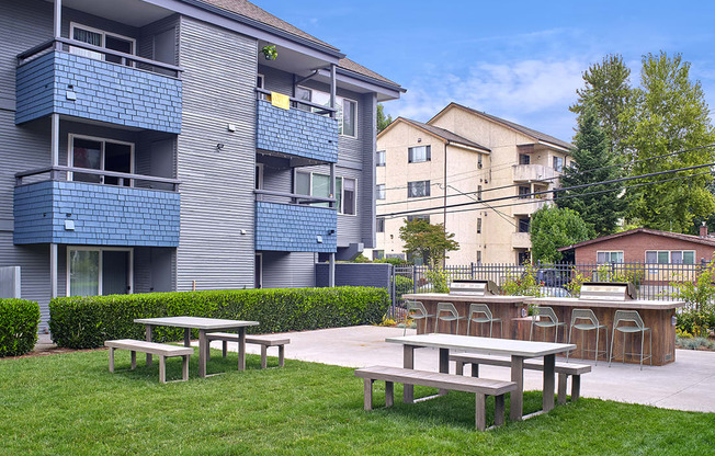 a picnic area with tables and chairs in front of an apartment building  at 3030 Lake City, Washington