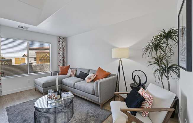 a living room with couches and a table and a large window