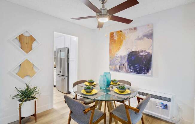 A dining room with a glass table and chairs at Verandas Apartments, West Covina