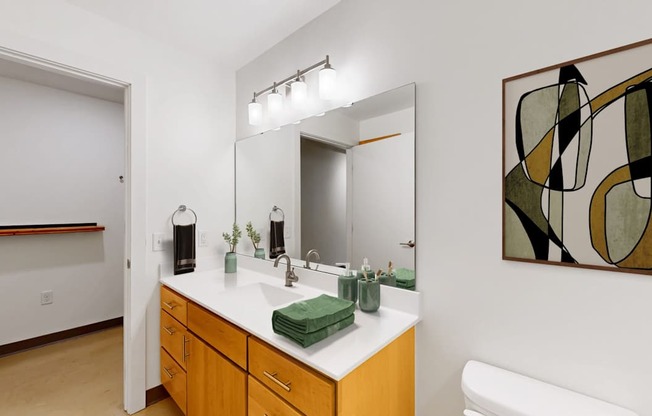 A bathroom with a white sink and a green towel.