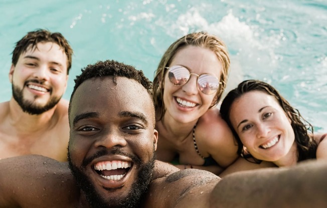 a group of people in the water smiling at the camera