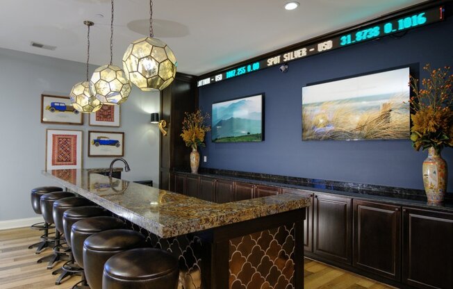 A bar with a row of stools and a counter with a patterned design.