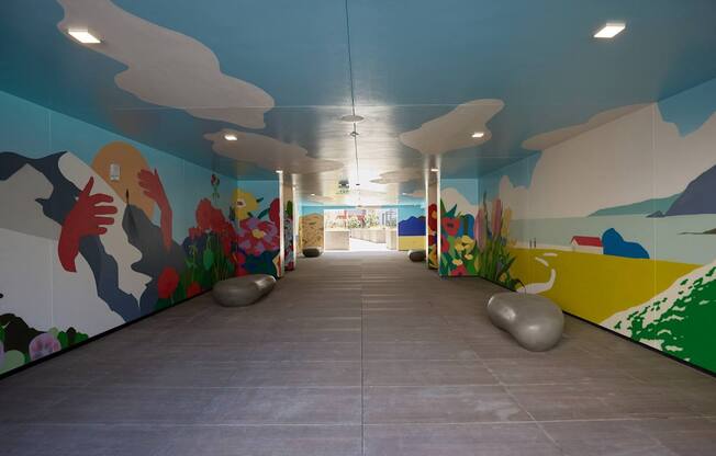 A hallway with a mural of a landscape and a person.