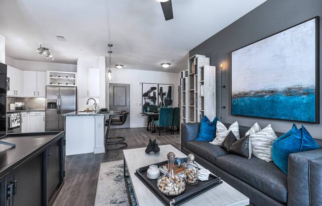 Open-concept floor plan featuring dining area, gourmet kitchen with stainless steel appliances, and spacious living room at Cyan Craig Ranch apartments for rent