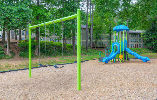 a playground with a blue and yellow swing set