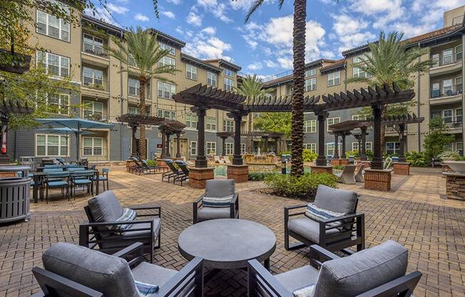 an outdoor patio with chairs and tables and buildings in the background