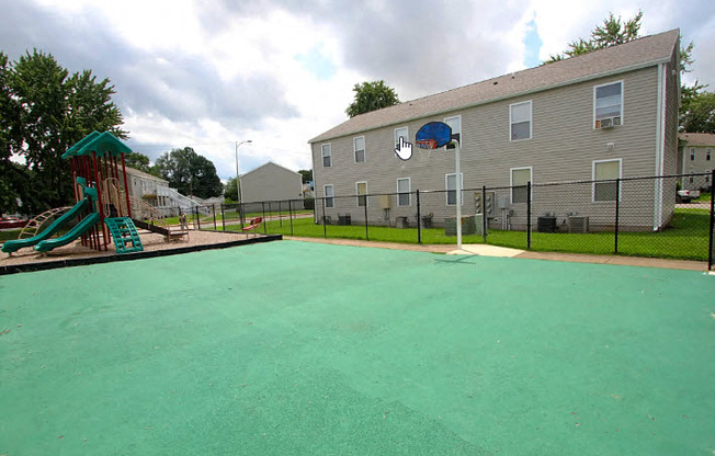 a large fenced in yard with a playground and a house