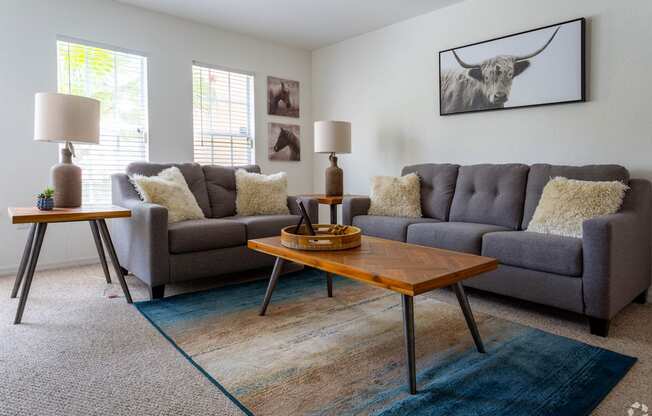 A living room with a grey couch and a wooden coffee table.