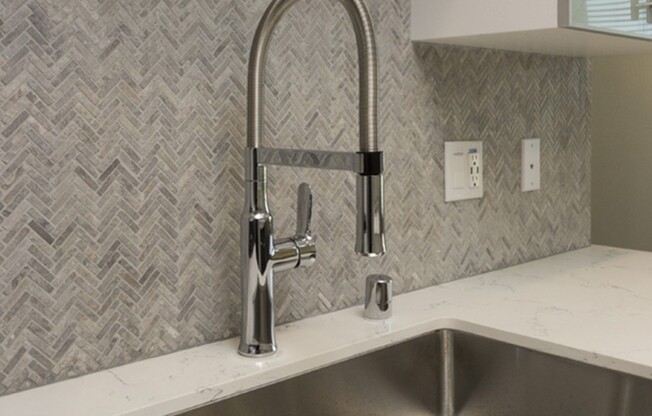 Moen faucets and USB ports with stunning tile backsplash