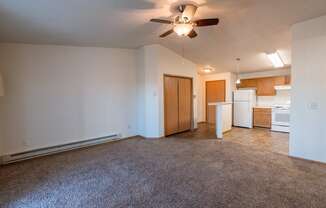 a living room with a kitchen and closet in the background. Fargo, ND Sunwood Apartments