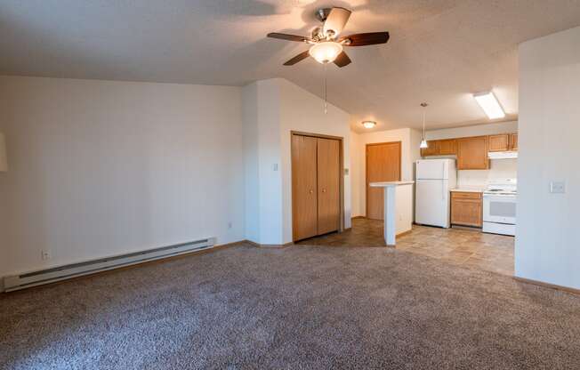 a living room with a kitchen and closet in the background. Fargo, ND Sunwood Apartments