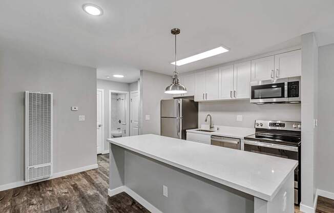 A modern kitchen with a large island and stainless steel appliances.