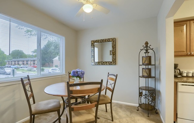 Mechanicsburg Apartments | Delbrook Manor Apartments | a dining room with a large window and a ceiling fan