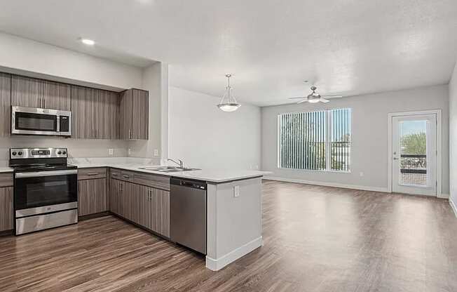 A spacious kitchen with wood flooring and stainless steel appliances.