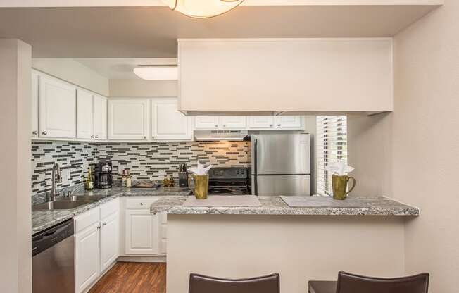 a kitchen with white cabinets and a granite counter top at Lodge of Overland Park Apartments, Kansas, 66212