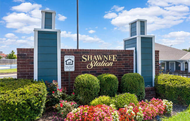 the sign for shawnee village with flowers in front of the building