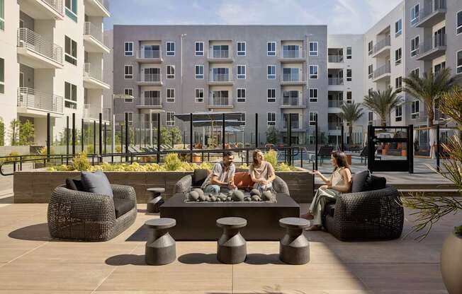 A group of people are sitting on a couch and chairs on a patio.