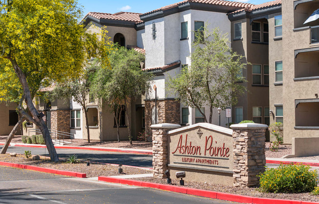 A sign for Ashon Pointe Apartments is in front of a building.