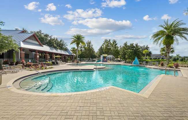 A large outdoor swimming pool surrounded by a brick patio and a covered pavilion at Wynnfield Lakes Apartments in Jacksonville, FL