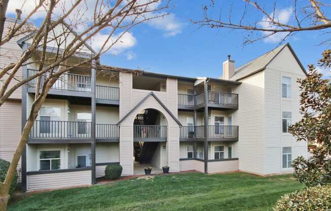 an exterior view of an apartment building with a lawn