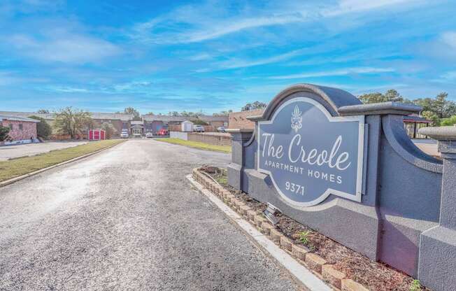 A stone sign for "The Creole Apartment Homes" is at the entrance to The Creole Apartments in Shreveport, LA
