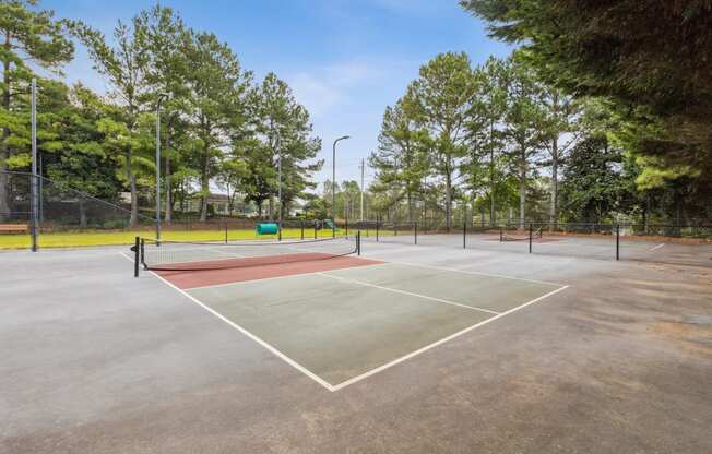 a tennis court with a red and green court in a park