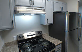 a kitchen with white cabinets and a stove and refrigerator