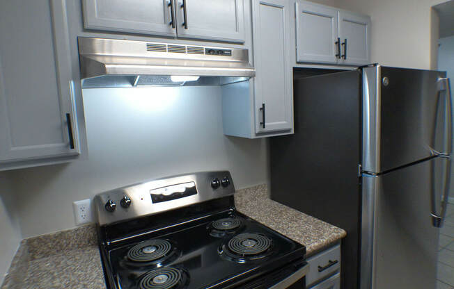 a kitchen with white cabinets and a stove and refrigerator
