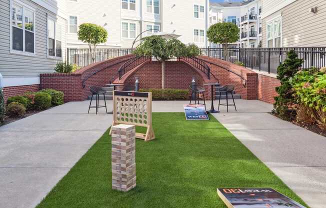 A small backyard with a brick wall and a green lawn.