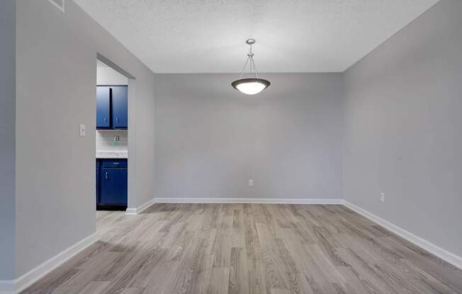A room with a blue cabinet and wooden flooring.