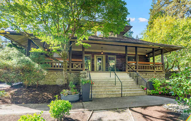 Building with a front porch and a tree in front.