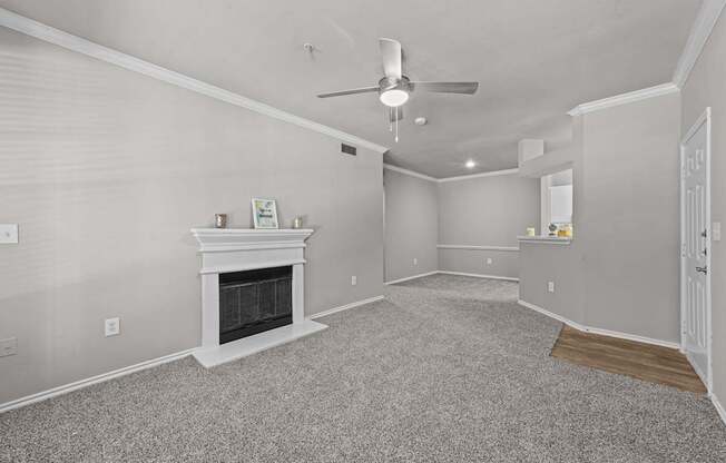 A living room with a fireplace and a ceiling fan.