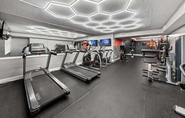 A gym with treadmills, exercise bikes, and other equipment.