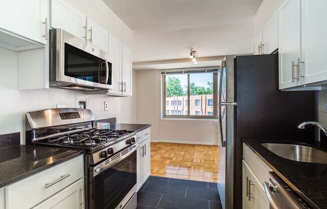 A kitchen with black countertops and white cabinets.