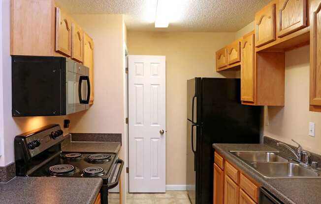 A kitchen with a black fridge and stove.