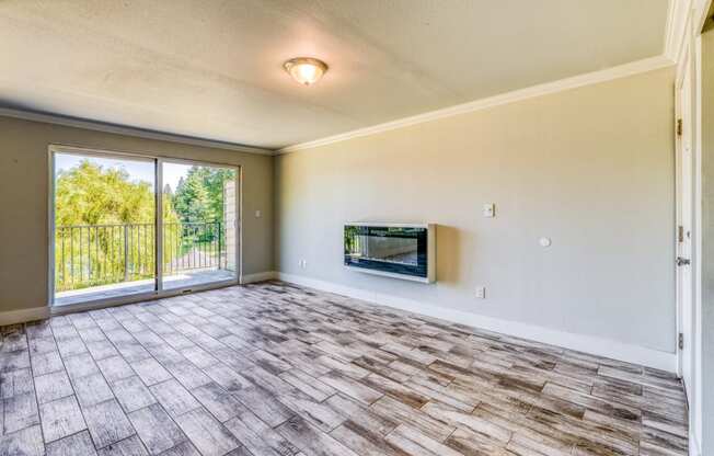 an empty living room with a fireplace and a sliding glass door