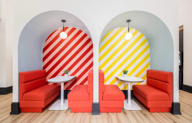 two orange chairs and tables in a room with two surfboards