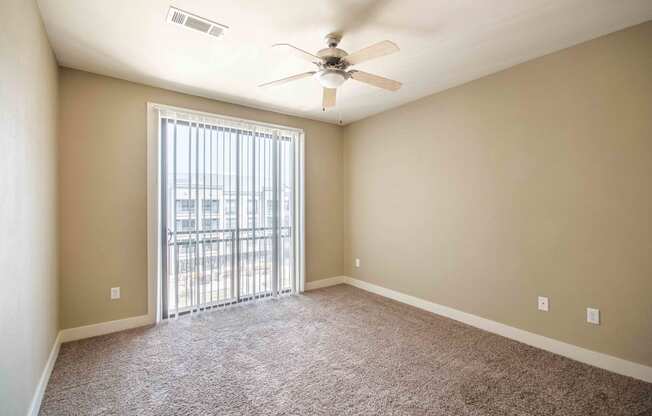 a bedroom with a ceiling fan and a window At Metropolitan Apartments in Little Rock, AR
