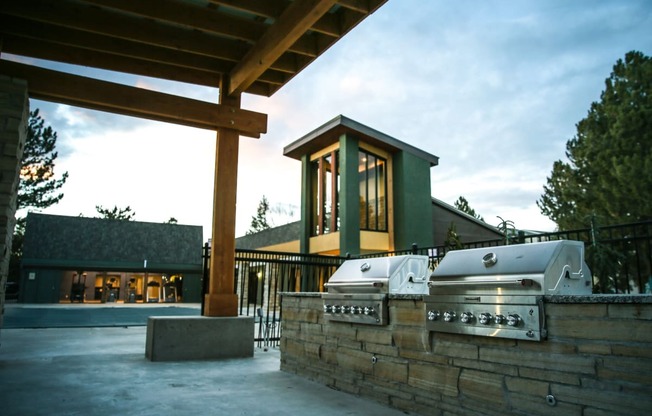 an outdoor entertaining area with a grill and a building