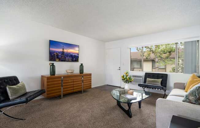 a living room with white walls and a large window