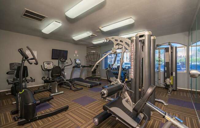 A gym with a variety of equipment including treadmills, stationary bikes, and weight machines at Sterling Point Apartment Homes, Phoenix, 85042