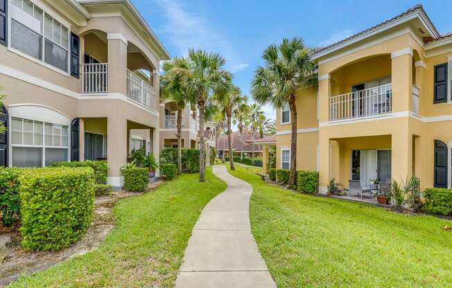 A row of apartment buildings with a walkway between them.