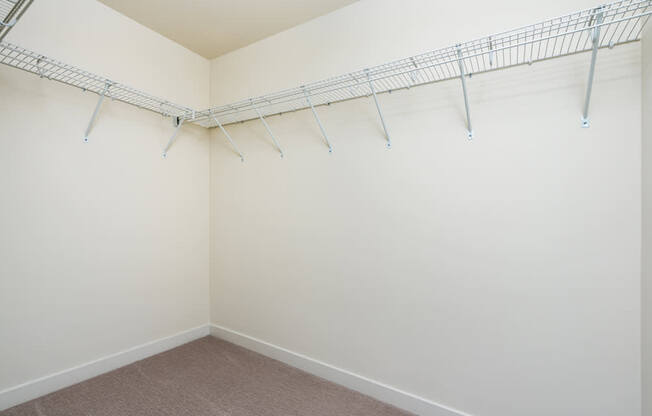 Empty room with a white wall and a metal rack on the wall.