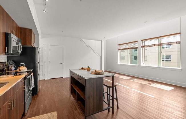 A kitchen with wooden cabinets and a black fridge.