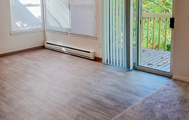 A room with a sliding glass door leading to a balcony.