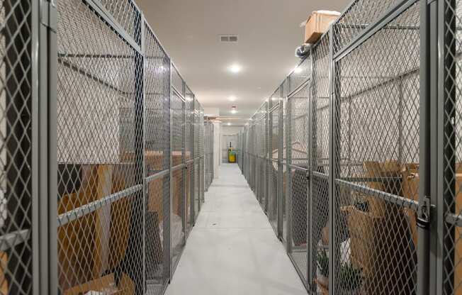 the inside of a prison cell with a long white hallway with metal cages and boxes