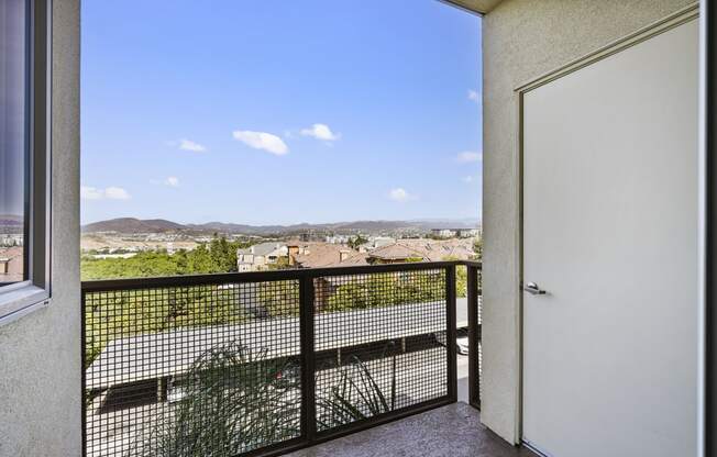 a balcony with a white door and a view of the city