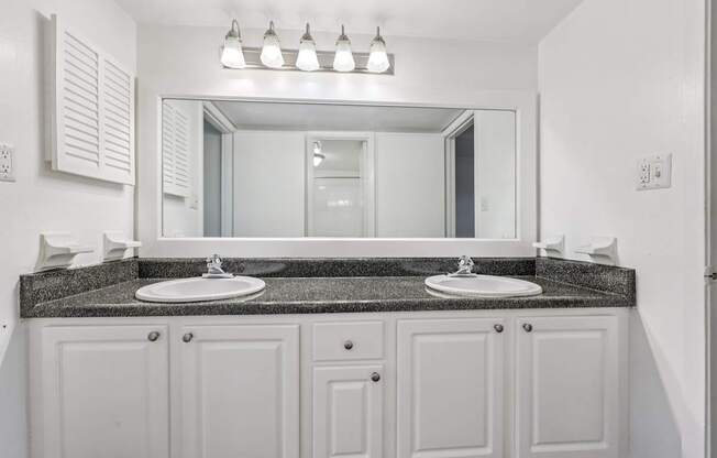 A bathroom with two sinks and a large mirror.