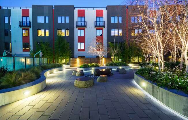 A modern building with a well-lit walkway in front.