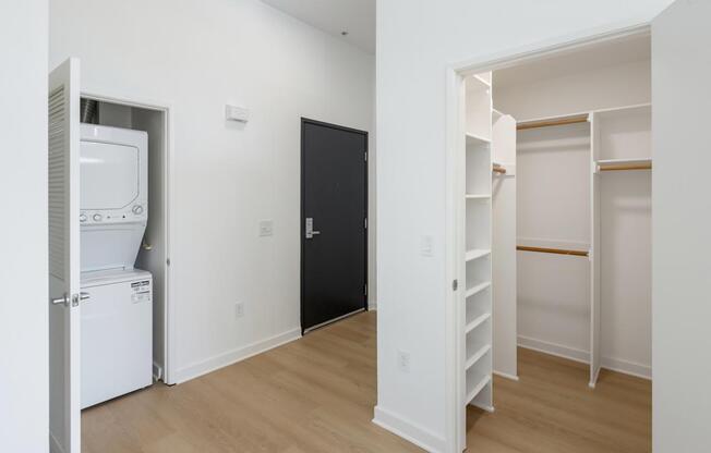 A black door is in the middle of a white wall.